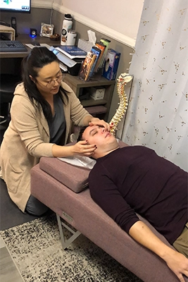 Chiropractor Las Vegas NV Justine Rhee Examining Patient